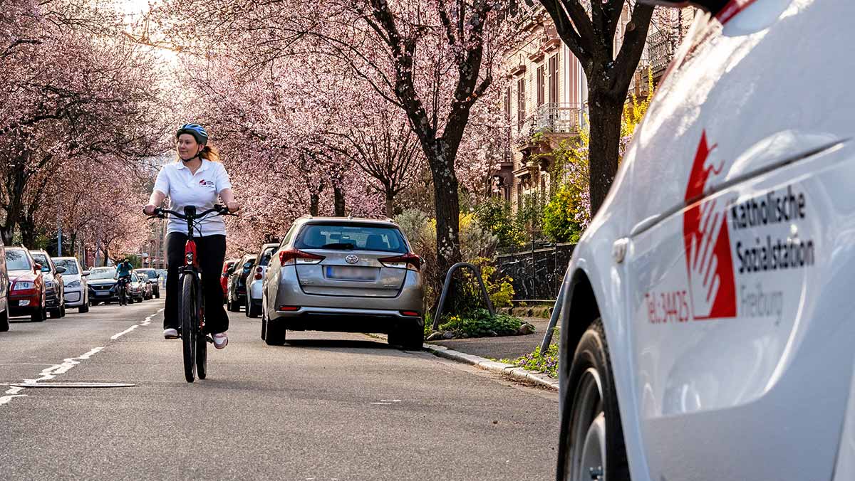 Pflegedienst Mitarbeiterin besucht Patienten mit dem Fahrrad