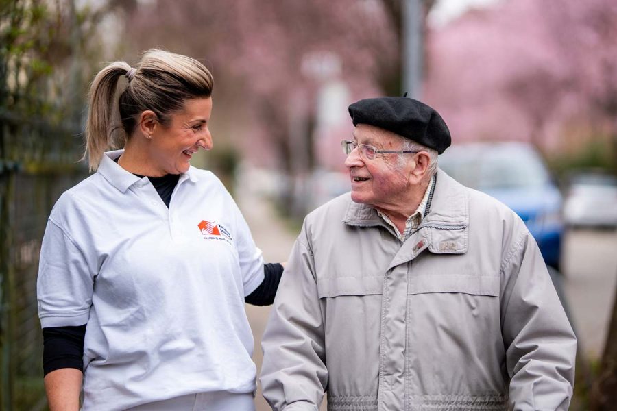 stellen-jobs-pflegedienst-pflegefachkraft-01 Pflegefachkraft im Gespräch mit dem Patienten bei einem Spaziergang