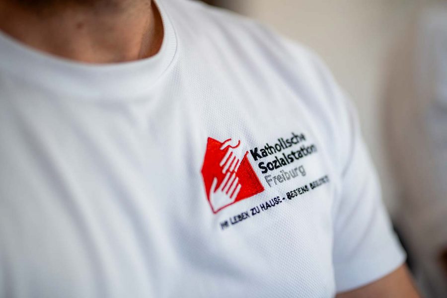 stellen-jobs-pflegedienst-pflegefachkraft-07 Pflegefachkraft mit T-Shirt der Katholischen Sozialstation Freiburg, Stellenangebote für Mitarbeiterinnen und Mitarbeiter den Bereichen Pflege, Beratung, Haushalt, Verwaltung.